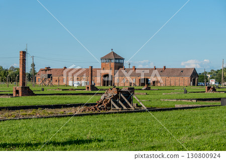 Auschwitz Birkenau Concentration and Extermination Camp. Barracks chimneys in front of the entrance gate 130800924