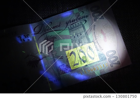 Inspecting Ukrainian Hryvnias Under Ultraviolet Light to Reveal Hidden Security Features Inspecting Ukrainian Hryvnias Under Ultraviolet Light to Reveal Hidden Security Features 130801750