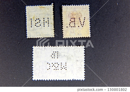 Unique Reverse Side of Postage Stamps Showcasing Intricate Perfins in a Philately Collection Unique Reverse Side of Postage Stamps Showcasing Intricate Perfins in a Philately Collection 130801802