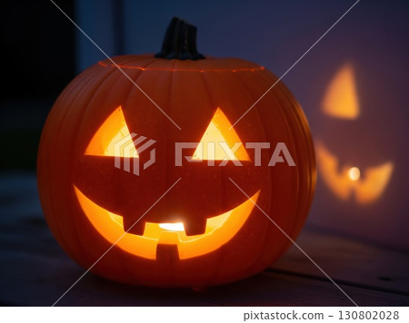 Carved pumpkin glowing brightly with smooth illuminated surface under evening light casting festive playful atmosphere with contrasting shadows in a seasonal holiday setting Carved pumpkin glowing brightly with smooth illuminated surface under evening light casting festive playful atmosphere with contrasting shadows in a seasonal holiday setting 130802028