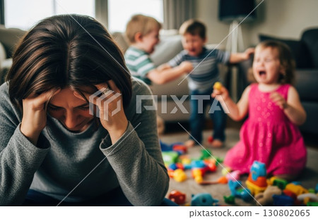 Exhausted parent sits on floor covering face, surrounded by mess and toys while toddlers cry in the background, showing emotional fatigue Exhausted parent sits on floor covering face, surrounded by mess and toys while toddlers cry in the background, showing emotional fatigue 130802065