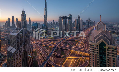 Dubai downtown skyline with tallest skyscrapers and busiest traffic on highway intersection night to day timelapse Dubai downtown skyline with tallest skyscrapers and busiest traffic on highway intersection night to day timelapse 130802797