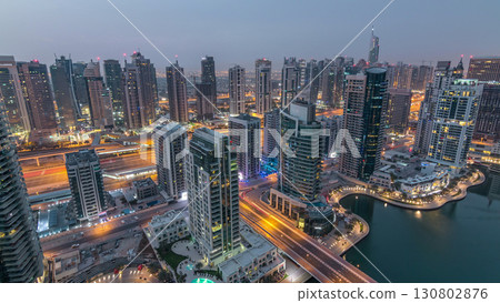 Aerial top view of Dubai Marina night to day timelapse. Modern towers and traffic on the road 130802876