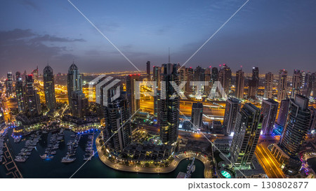 Aerial top view of Dubai Marina night to day timelapse. Modern towers and traffic on the road 130802877