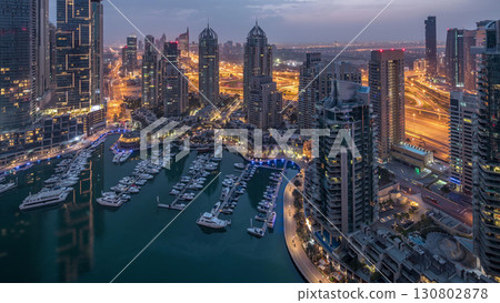 Aerial top view of Dubai Marina night to day timelapse. Modern towers and traffic on the road 130802878