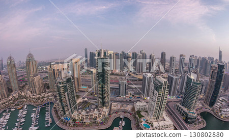 Aerial top view of Dubai Marina day to night timelapse. Modern towers and traffic on the road 130802880