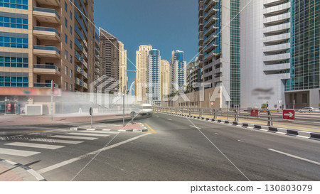 Dubai Marina with Skyscrapers timelapse hyperlapse and traffic on the street near concrete road bridge through the canal Dubai Marina with Skyscrapers timelapse hyperlapse and traffic on the street near concrete road bridge through the canal 130803079