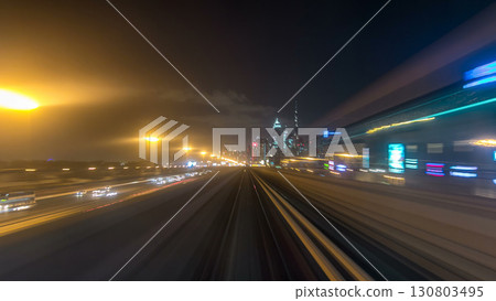 Front cabin POV view from modern driver-less metro train rush forward, along night Dubai, smooth timelapse. 130803495