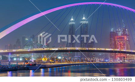 Pedestrian Bridge over the Dubai Water Canal day to night timelapse, United Arab Emirates 130803499