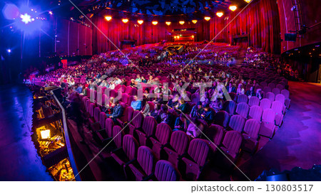 Spectators gather in the auditorium and watch the show in theatre timelapse. Large hall with red armchairs seats Spectators gather in the auditorium and watch the show in theatre timelapse. Large hall with red armchairs seats 130803517