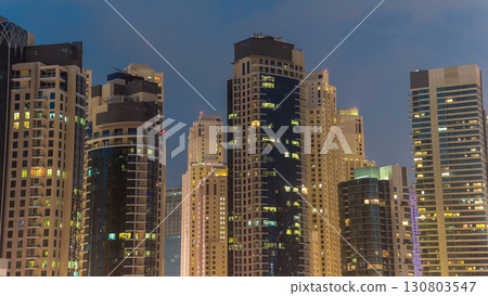 Evening Dubai marina city center with floating vessels day to night timelapse 130803547