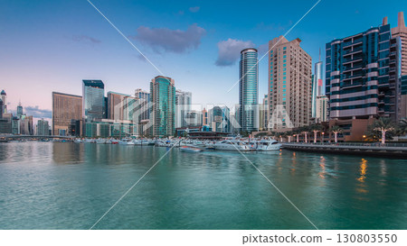Dubai Marina towers and yachts reflected in water of canal in Dubai day to night timelapse Dubai Marina towers and yachts reflected in water of canal in Dubai day to night timelapse 130803550