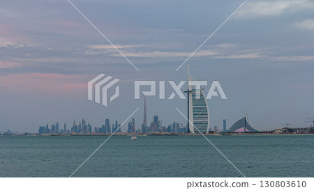 Dubai skyline with Burj Al Arab hotel during sunset and day to night timelapse. Dubai skyline with Burj Al Arab hotel during sunset and day to night timelapse. 130803610