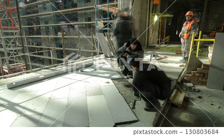 Industrial tiler builders workers installing floor tile at repair renovation work timelapse 130803684