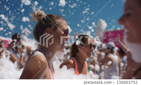 Smiling friends enjoying a lively foam party under the bright summer sun Smiling friends enjoying a lively foam party under the bright summer sun 130803752