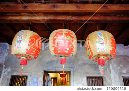 Beautiful traditional of golden Chinese paper lantern with red Chinese characters hanging on wooden ceiling in natural sunlight on Chinese New Year holiday 130804816