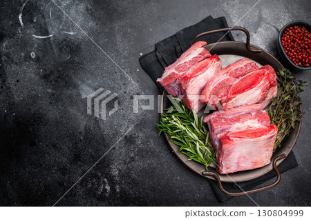 Raw Beef Short Rib, uncooked meat with bone and fat. black background. top view Raw Beef Short Rib, uncooked meat with bone and fat. black background. top view 130804999