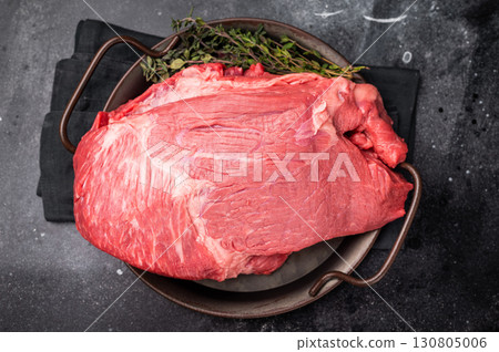 Raw Top Round beef meat cut, topside with hrebs for roast. black background. Top view 130805006