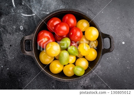 Uncooked small tomatoes. red, green and yellow cherry tomatoes assortment, cocktail mix. black background. top view 130805012