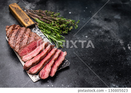 Savory shoulder steak Denver, beautifully cooked on the grill, highlighting its marbled texture and succulent taste. black background. top view 130805023