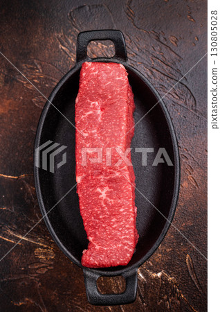 Tender wagyu loin, displaying its luscious fat distribution and deep color. An exquisite ingredient for creating unforgettable meals at home. brown background. top view Tender wagyu loin, displaying its luscious fat distribution and deep color. An exquisite ingredient for creating unforgettable meals at home. brown background. top view 130805028