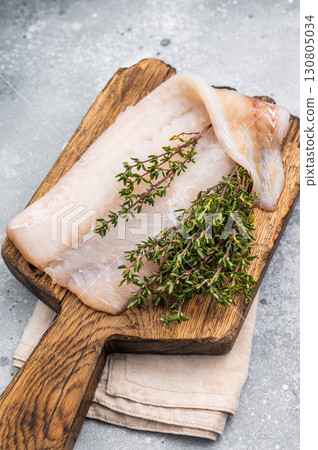 Fresh cod fish fillet, showcasing its delicate texture and pristine color, perfect for grilling or baking. grey background. top view 130805034