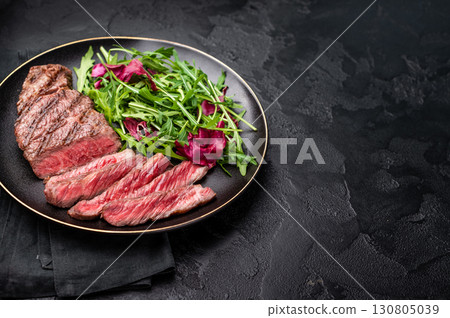 Succulent Denver cut, showcasing a perfect sear and rich color after grilling. black background. top view 130805039