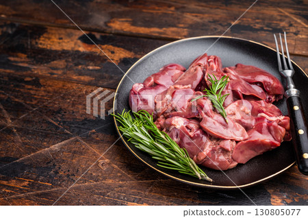 Raw chicken liver, featuring a glossy sheen and rich hue. A versatile ingredient that brings bold flavors to any culinary creation. wooden background. top view 130805077
