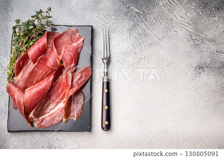 Sliced Speck bacon, Italian cured meat. grey background. top view 130805091