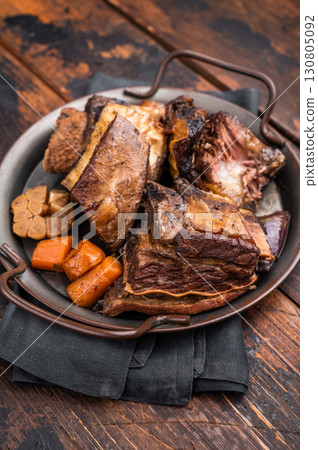 Grilled beef short ribs glistening under natural light, accompanied by fresh greens and spices, capturing the essence of gourmet comfort food. wooden background. top view Grilled beef short ribs glistening under natural light, accompanied by fresh greens and spices, capturing the essence of gourmet comfort food. wooden background. top view 130805092