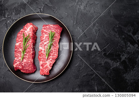 High-quality Denver cut, featuring a perfect balance of fat and meat steak. A great choice for those seeking a flavorful and juicy steak experience. black background. top view 130805094