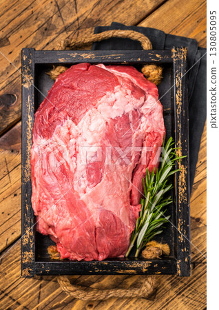 Raw beef boneless shank meat with visible marbling, ready for braising or roasting, offering a flavorful addition to any gourmet dish or family dinner. wooden background. top view 130805095