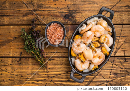 Ready for cooking fresh Raw Seafood Cocktail with Mussels, Clams, Prawns, Shrimps and squid in skillet. wooden background. top view 130805110