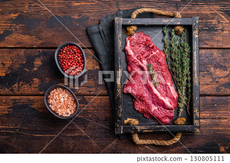 Uncooked hanging tender beef steak, Hanger steak in wooden tray with herbs. wooden background. top view 130805111