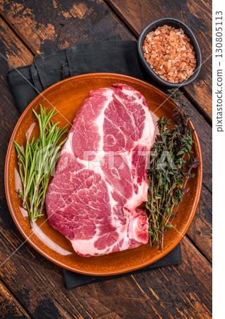 Raw pork tender loin steak, fresh neck meat with herbs. wooden background. top view 130805113