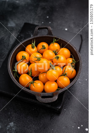 Fresh small yellow tomatoes, cherry tomatoes assortment, cocktail mix. black background. top view Fresh small yellow tomatoes, cherry tomatoes assortment, cocktail mix. black background. top view 130805179