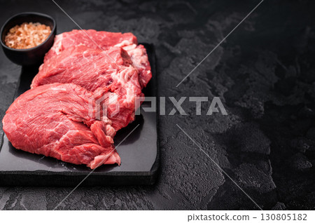 Raw beef boneless shank shin presented with herbs and spices, inspiring bold flavors and unique recipes for adventurous home cooks. black background. top view Raw beef boneless shank shin presented with herbs and spices, inspiring bold flavors and unique recipes for adventurous home cooks. black background. top view 130805182