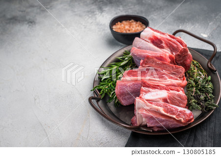 Raw lamb Riblets, fresh mutton meat with rib bone. grey background. top view Raw lamb Riblets, fresh mutton meat with rib bone. grey background. top view 130805185