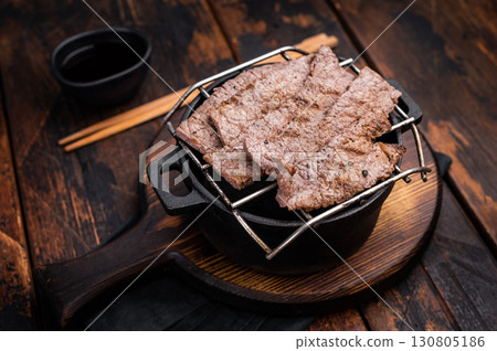 Flavorful yakiniku with juicy wagyu beef slices cooked right at the table. wooden background. top view 130805186