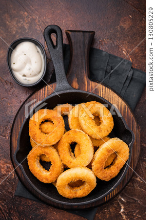 Crispy Fried onion rings, delicious snack in a pan. brown background. top view 130805229