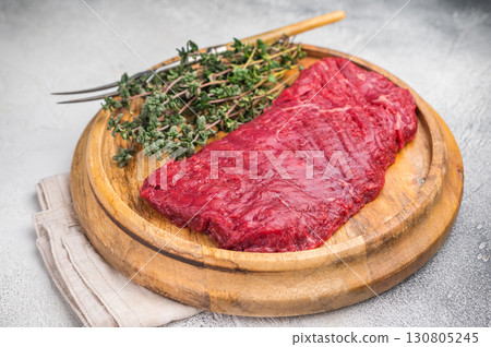Flank steak, raw beef meat with herbs for frying. grey background. top view 130805245