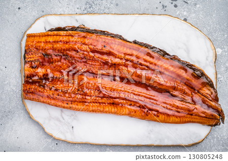 Unagi eel, Japanese grilled fish fillet of eel with sauce. grey background. top view Unagi eel, Japanese grilled fish fillet of eel with sauce. grey background. top view 130805248