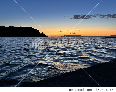 夕陽的天空和地平線透過漣漪 130805257