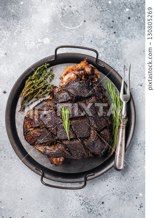 Slow cooked venison roast leg. Braised game meat of deer with bone. grey background. top view Slow cooked venison roast leg. Braised game meat of deer with bone. grey background. top view 130805269