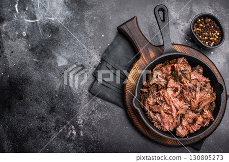 Traditional barbecue pulled beef, Slow cooked meat cooked in a smoker. black background. top view Traditional barbecue pulled beef, Slow cooked meat cooked in a smoker. black background. top view 130805273