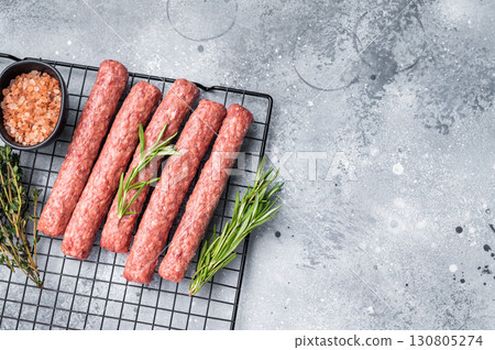 Raw beef and lamb meat kebabs sausages, kofta kebab. grey background. top view Raw beef and lamb meat kebabs sausages, kofta kebab. grey background. top view 130805274