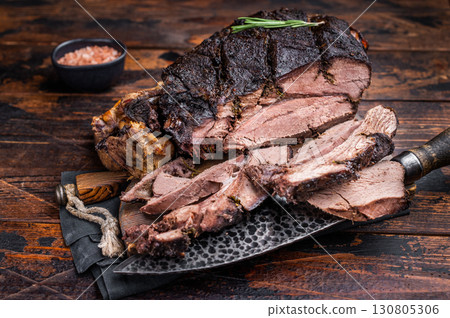 Slow ccoked sliced Venison leg, roasted game meat of deer on a board with herbs. wooden background. top view Slow ccoked sliced Venison leg, roasted game meat of deer on a board with herbs. wooden background. top view 130805306