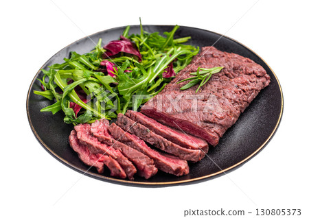 Grilled and sliced Flank beef steak on plate with salad isolated on white background. top view Grilled and sliced Flank beef steak on plate with salad isolated on white background. top view 130805373