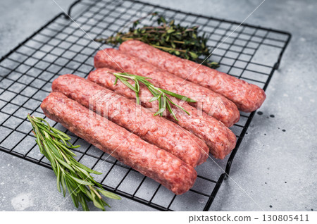 Raw beef and lamb meat kebabs sausages, kofta kebab. grey background. top view Raw beef and lamb meat kebabs sausages, kofta kebab. grey background. top view 130805411