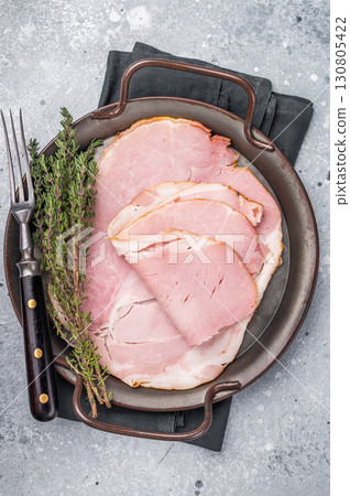 Thinly sliced pork ham, smoked meat. grey background. top view Thinly sliced pork ham, smoked meat. grey background. top view 130805422